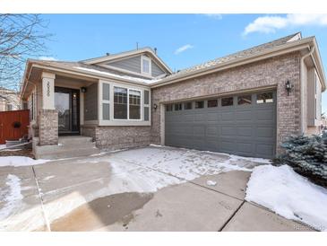Charming exterior of a ranch-style home with gray siding and a spacious two-car attached garage at 20500 E Hamilton Ave, Aurora, CO 80013