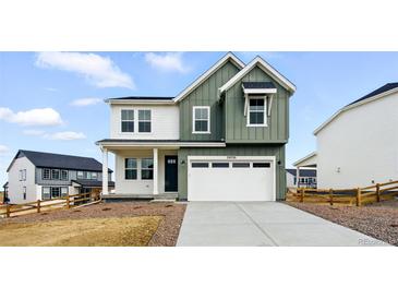Two-story home boasts a two-car garage, and a blend of white and green siding at 39730 Congress Ln, Elizabeth, CO 80107