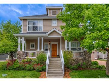 Charming home featuring a welcoming front porch with stone accents, white columns, and beautiful landscaping at 4921 Fountain St, Boulder, CO 80304