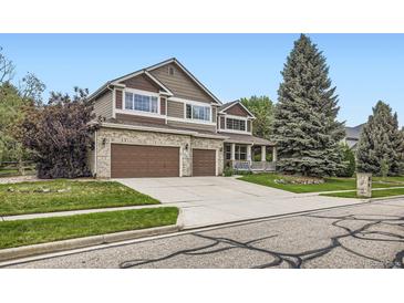 Charming two-story home with a well-manicured lawn, mature trees, and a three-car garage at 2215 Parkview Dr, Longmont, CO 80504