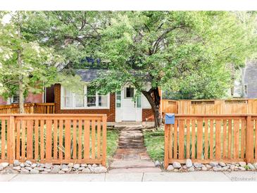 Charming brick home with a cozy front yard, featuring a picket fence and mature tree at 3346 W 30Th Ave, Denver, CO 80211