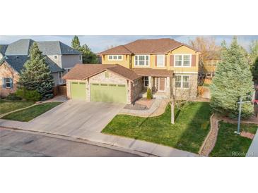 Charming two-story home boasts a three-car garage, beautiful lawn, and mature trees at 13664 Cherry St, Thornton, CO 80602