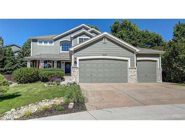 Charming two-story home featuring an attached three-car garage and beautifully landscaped front yard at 8229 Cottongrass Ct, Castle Pines, CO 80108