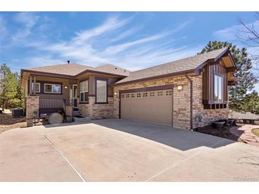Charming home with stone accents, a two-car garage, and a cozy front porch sitting area at 7370 S Catawba Way, Aurora, CO 80016