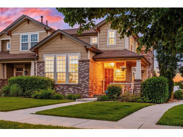 Charming home with a brick and siding exterior, manicured lawn, and a welcoming front porch, perfect for relaxing sunsets at 1047 Uinta Way, Denver, CO 80230