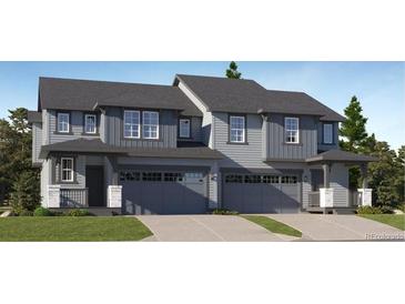Charming townhome with a two-car garage, covered porch and a professionally landscaped front yard at 587 Nightsky St, Erie, CO 80516