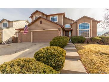 Charming two-story home featuring a two-car garage, landscaped yard, and covered entryway at 4094 S Lisbon Way, Aurora, CO 80013