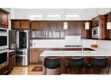 Gourmet kitchen features stainless steel appliances and a sleek breakfast bar at 7080 W Custer Ave, Lakewood, CO 80226