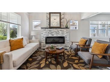 Cozy living room with stone fireplace, modern furniture, and beautiful area rug at 3929 Federal Blvd, Denver, CO 80211