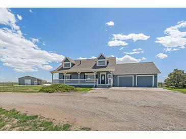 Charming two-story home featuring a welcoming front porch and an attached three-car garage at 32800 E 137Th Way, Brighton, CO 80603