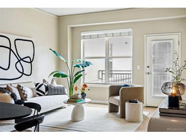 Bright living room features large window, comfortable seating and stylish décor, creating an inviting and modern space at 1975 N Grant St # 810, Denver, CO 80203