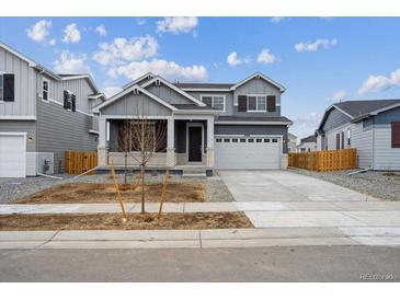 Beautiful two-story home with a two-car garage and a covered front porch entrance at 9996 Racine St, Commerce City, CO 80022