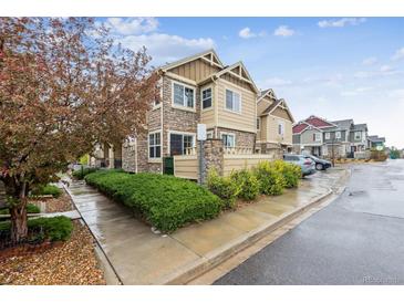 Charming two-story townhouse showcasing stone and siding accents with manicured front yard landscaping at 23535 E Platte Dr # A, Aurora, CO 80016