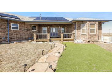 Charming brick home featuring a welcoming porch and a stone pathway leading to the front door at 44000 E 88Th Ave, Bennett, CO 80102