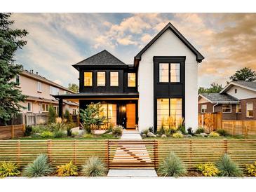 Stunning two-story home with black trim, white painted brick, and professionally landscaped front yard at 1983 S Logan St, Denver, CO 80210
