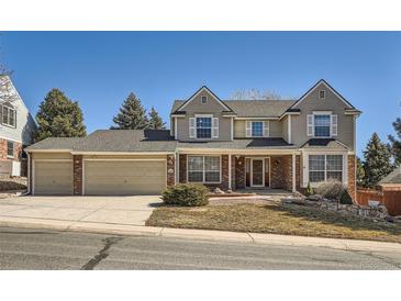 Traditional two-story home boasts a three-car garage and a manicured front yard at 4240 S Yukon Way, Lakewood, CO 80235