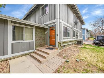 Charming exterior showcasing the front door, brick accents, and well-maintained landscaping at 1212 S Uvalda St, Aurora, CO 80012