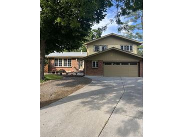 Charming two-story home with a brick facade, attached two-car garage, and spacious driveway at 12625 W 66Th Cir, Arvada, CO 80004