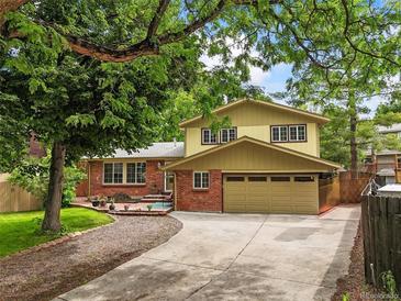 Two-story home featuring a charming brick facade and attached two-car garage at 12625 W 66Th Cir, Arvada, CO 80004