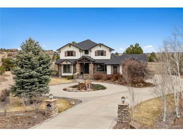 A beautiful two-story home with a circular driveway and stone accents at 5375 Twilight Way, Parker, CO 80134