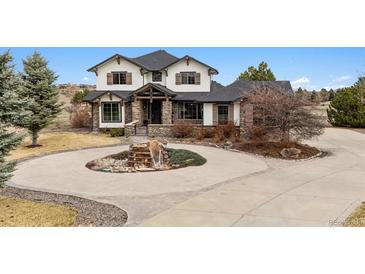 Charming home featuring stone accents, a circular driveway, and beautiful landscaping at 5375 Twilight Way, Parker, CO 80134