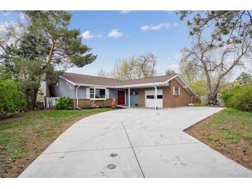 Charming ranch-style home with a brick and siding exterior, long driveway and mature trees, perfect for suburban living at 4634 S Adobe Ct, Littleton, CO 80127