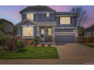 Charming two-story home with a well-manicured lawn, inviting entrance, and an attached two-car garage at 11569 Grape St, Thornton, CO 80233