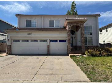 Charming two-story home featuring a two-car garage, arched entryway and a well-maintained lawn at 20304 E 47Th Pl, Denver, CO 80249