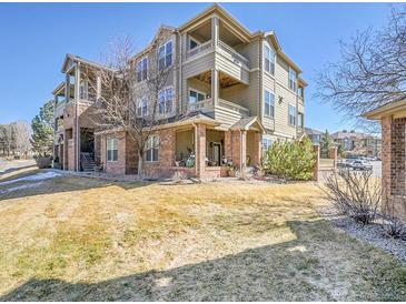 Attractive three-story condo building with brick accents and charming covered patios on a well-maintained lawn at 12768 Ironstone Way # 204, Parker, CO 80134