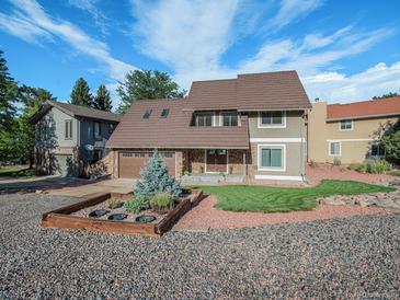 Charming two-story home featuring a unique stone facade, well-manicured lawn, and appealing landscaping at 15789 Sandtrap Way, Morrison, CO 80465