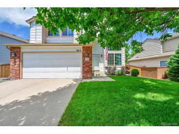 Charming two-story home with a lush green lawn and a two car garage at 9717 Castle Ridge Cir, Highlands Ranch, CO 80129