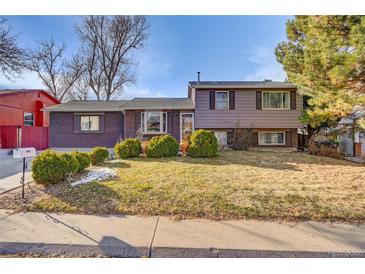 Charming front exterior features a well-maintained lawn, mature trees, and tasteful landscaping at 2551 S Carson Way, Aurora, CO 80014