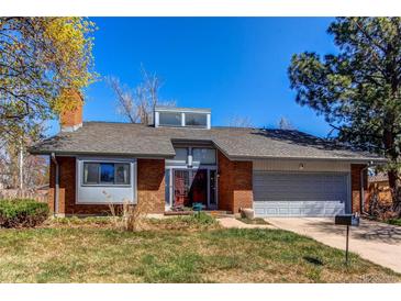 Charming red brick single-Gathering home with a two-car garage and manicured front lawn at 11651 E Yale Way, Aurora, CO 80014
