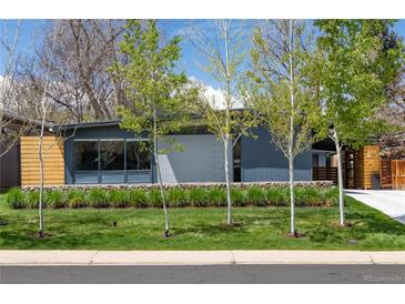 Modern home featuring a gray exterior, well-maintained lawn, and young trees in a serene suburban setting at 1321 S Edison Way, Denver, CO 80222
