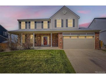 Charming two-story home features a covered porch, attached two-car garage, and well-maintained lawn at 11715 Crow Hill Dr, Parker, CO 80134