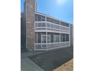 Gray apartment building with balconies and a stone accent wall near the stairwell at 18051 E Kentucky Ave # 201, Aurora, CO 80017