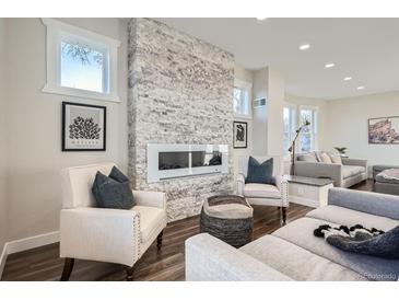 Bright living room featuring a modern fireplace and seating area with stylish decor and plenty of natural light at 4385 Carr St, Wheat Ridge, CO 80033