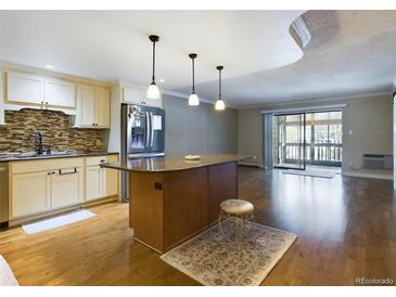 Updated kitchen with island, stainless steel appliances, and hardwood floors at 14000 E Linvale Pl # 110, Aurora, CO 80014