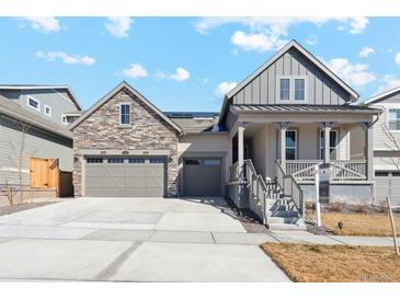 Charming home featuring a stone accented three car garage, covered porch and manicured lawn at 17163 Desert Wine Trl, Parker, CO 80134