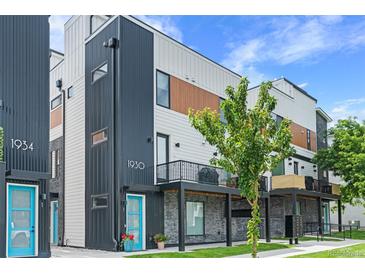 Modern townhome exterior with a blue door, black metal accents, and a small balcony with grilling equipment at 1930 Hooker St # 3, Denver, CO 80204
