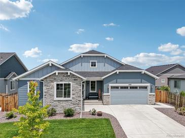 Charming two-story home featuring stone accents, a two-car garage, and a well-manicured front yard at 15987 E 115Th Pl, Commerce City, CO 80022