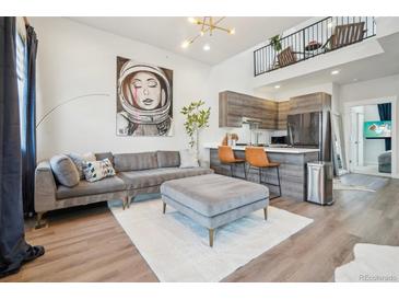 Stylish living room featuring a modern sofa, ottoman, and a striking art piece at 3550 W 63Rd Ave, Denver, CO 80221