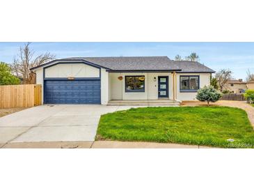 Charming single-story home featuring a well-manicured lawn, a blue two-car garage, and a welcoming front entrance at 2484 E 101St Ct, Thornton, CO 80229