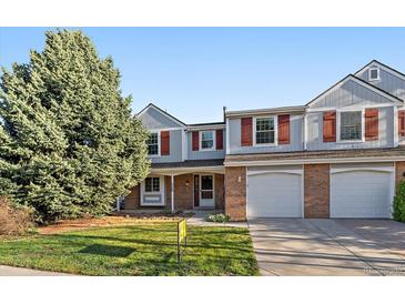 Charming two-story townhome featuring a two-car garage, mature trees, and landscaped front yard at 6459 E Hinsdale Ave, Centennial, CO 80112