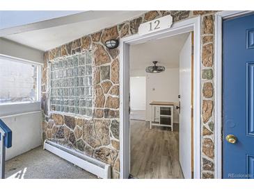 Inviting entryway with stone accent wall, modern lighting, and a glimpse into the interior with stylish flooring at 1265 Colorado Blvd # 12, Denver, CO 80206