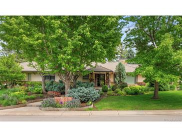 Landscaped front yard with mature trees and well-manicured bushes and stone accents in a beautiful residential area at 3401 E Kentucky Ave, Denver, CO 80209