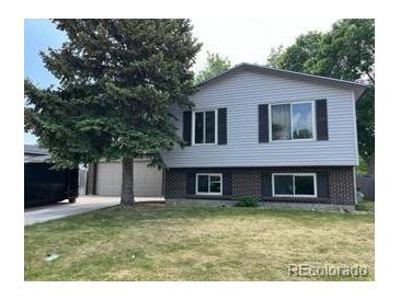 Traditional two-story home with a well-manicured front yard and a mature shade tree at 11318 Clermont Dr, Thornton, CO 80233