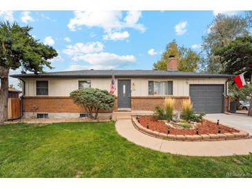 Ranch style home with brick facade, landscaped yard, and attached garage at 1586 S Field Ct, Lakewood, CO 80232