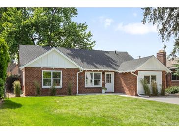 Charming brick home with a well-manicured lawn, lovely landscaping, and eye-catching architectural details at 2635 Kearney St, Denver, CO 80207