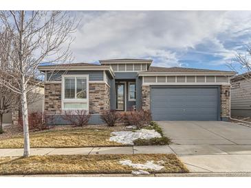 House exterior features stone and siding accents, a two-car garage, and a manicured lawn at 12432 Meadowlark Ln, Broomfield, CO 80021